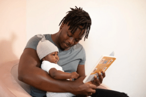 a man reading a book to his baby